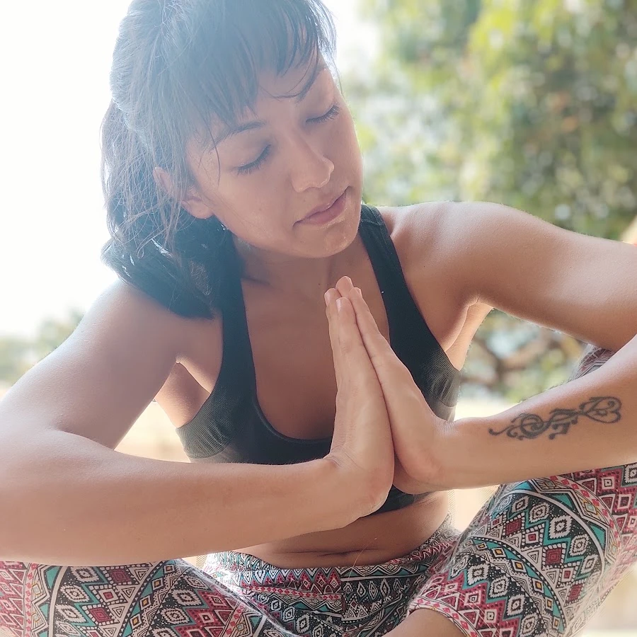 Anastasia seated with her palms joined, in soft natural light